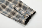 Plaid shirt with a button on a light gray background