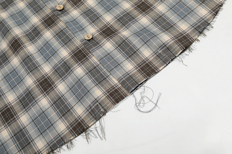Plaid fabric with a frayed edge on a white background